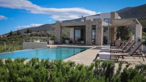 a villa with a swimming pool and lounge chairs at Villa Thymari in Xiropigado