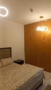 a bedroom with a bed and a chandelier at Oasis TOWER 1105 in Ajman 