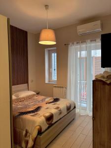 a bedroom with a bed and a large window at Il Palazzetto in Gaeta