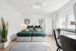 a bedroom with a green bed and a table at Übernachtung an der A2 in Braunschweig