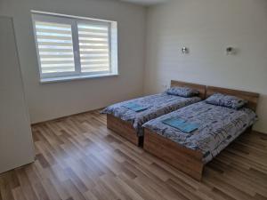 two beds in a room with a window at FB kotedžo apartamentai in Kretinga
