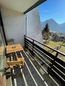a table and chair on a balcony with a view at Studio Pod Kaninom in Bovec