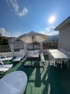 a patio with a table and chairs and an umbrella at Amazon Jade Hotel Boutique in San Bartolomé Milpas Altas