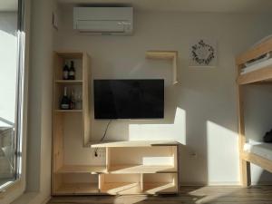 a living room with a tv on a wall at Studio Pod Kaninom in Bovec
