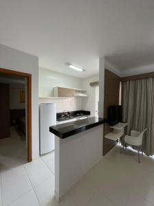 a kitchen with a refrigerator and a counter top at Flat Veredas Rio Quente-GO in Rio Quente