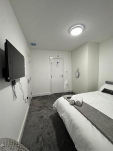 a bedroom with a bed and a flat screen tv at London Heathrow Uxbridge Escape in Uxbridge