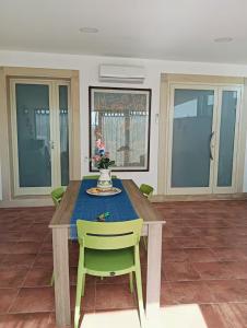 a dining room table with a green chair and a vase on it at DomusVenere in Santa Croce Camerina +21 photos