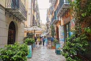 a narrow street with people walking down it at A due passi dal Teatro Massimo in Palermo