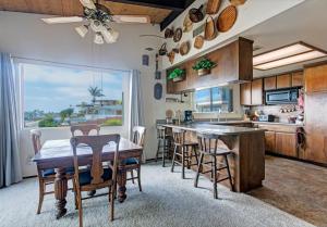 a kitchen with a table and chairs and a kitchen with a window at Catch some waves! Panoramic ocean views!- Cardiff Surfer in Cardiff-by-the-Sea