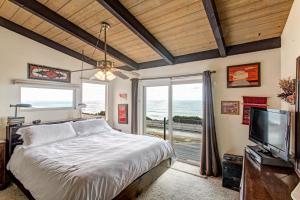 a bedroom with a bed and a tv and a window at Catch some waves! Panoramic ocean views!- Cardiff Surfer in Cardiff-by-the-Sea