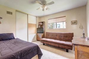 a bedroom with a bed and a couch and a tv at Catch some waves! Panoramic ocean views!- Cardiff Surfer in Cardiff-by-the-Sea