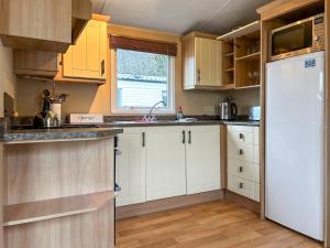 a kitchen with white cabinets and a white refrigerator at Uk51366 - The Harley Davidson in Brechin