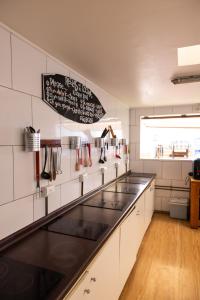 a kitchen with white walls and a black counter top at Aotea Backpacker Hostel in Iquique