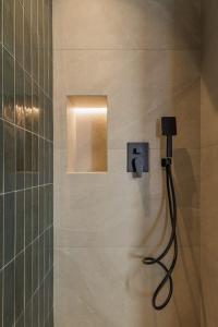 a shower in a bathroom with a light on the wall at Mouragia by Kantoni in Corfu +44 photos