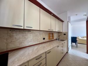 a kitchen with white cabinets and a counter top at Lighthouse Rafailovići, Budva in Rafailovici