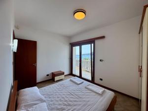 a bedroom with a bed and a large window at Lighthouse Rafailovići, Budva in Rafailovici