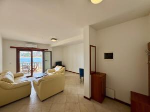a living room with couches and a view of the ocean at Lighthouse Rafailovići, Budva in Rafailovici