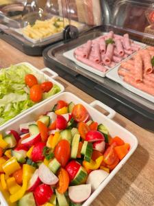 a table with two trays of vegetables and meats at Sport hotel POMI in Harrachov