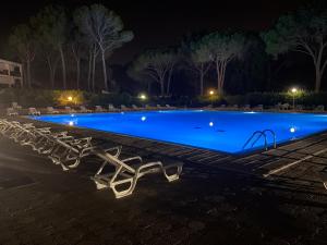 a swimming pool at night with chairs around it at Studio Rez de jardin coté piscine - Clim in Saint-Raphaël