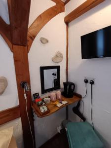 a room with a small table with a television and a table sidx sidx at Birchwood Guest Lodge in Balmaha