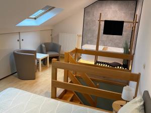 a small room with a bed and a chair and a table at Duplex vernieuwd appartement Dujardin bubbelbad in Blankenberge