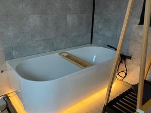 a white bath tub in a room with a staircase at Duplex vernieuwd appartement Dujardin bubbelbad in Blankenberge +24 photos