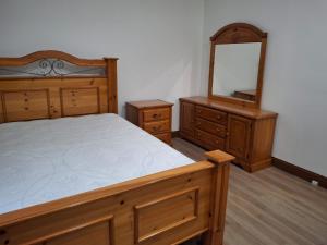 a bedroom with a bed and a dresser and a mirror at Downtown residence room 1 in Guelph