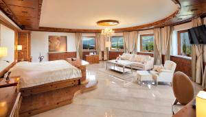 a bedroom with a large bed and a living room at Kaiserhof Superior in Ellmau