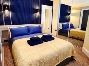 a bedroom with a large bed with blue pillows on it at Bournemouth Luxury Apartment in Bournemouth