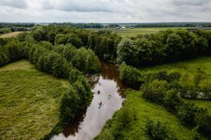 a group of people in a river in a field at Camping Hunze Bulten in Annen