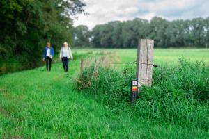 two people walking down a path in a field at Camping Hunze Bulten in Annen