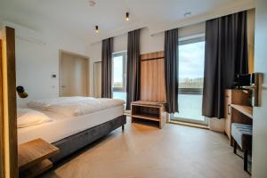 a bedroom with a bed and a large window at MSLiving Hotels in Hannover +57 photos