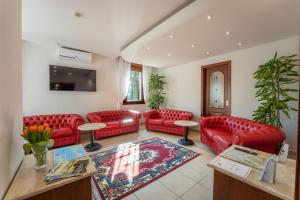 a living room with red leather couches and a table at Hotel Gardenia Sirmione in Sirmione