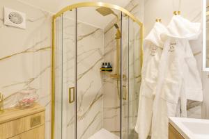 a bathroom with a shower and white towels on a rack at Just us Two - North East Escapes in Amble