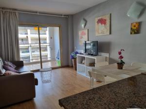 a living room with a table and a tv at RESIDENCIAL MICHELANGELO in Salou
