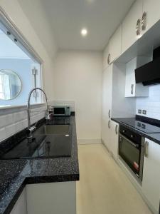 a kitchen with a sink and a counter top at Pier View 2 Bedroom Apartment in Herne Bay