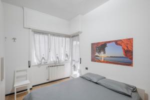 a white bedroom with a bed and a window at Casa Vacanze MaRoSa - Rapallo, Bixio in Rapallo