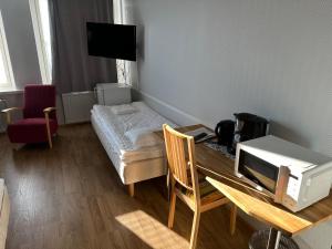 a room with a table with a microwave and a bed at Casual Housing Kemi in Kemi +7 photos