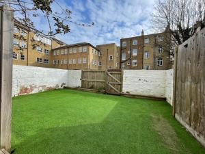 a courtyard with a green lawn in front of a building at Pier View 2 Bedroom Apartment in Herne Bay