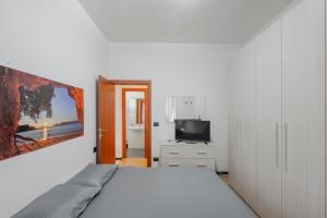 a white bedroom with a bed and a tv at Casa Vacanze MaRoSa - Rapallo, Bixio in Rapallo