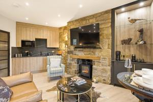 a living room with a stone wall and a fireplace at Just us Two - North East Escapes in Amble