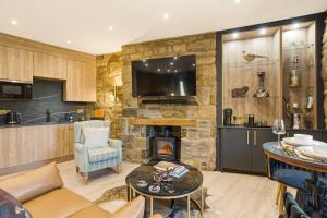 a kitchen and living room with a stone wall at Just us Two - North East Escapes in Amble