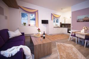 a living room with a purple couch and a table at LandAroma in Bestensee