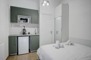 a small kitchen with a bed and a microwave at RHUM B07 - Old Town Courtyard in Bucharest +75 photos