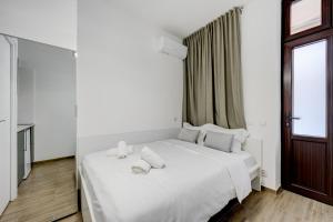 a white bed in a room with a window at RHUM B07 - Old Town Courtyard in Bucharest