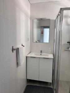 a white bathroom with a sink and a mirror at Sunset Star II With Sea View in Calheta +49 photos