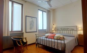 a bedroom with a bed and a chair and windows at Elle Palace - Simply Elegant in Verona