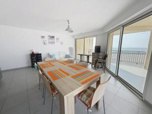 a dining room with a table and a view of the ocean at Les Sables 4 in Fort-Mahon-Plage
