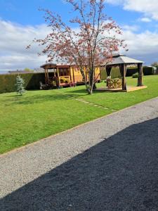 a house with a tree and a gazebo at Roulotte la passe pierre in Pendé