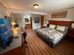 a hotel room with a bed and a flat screen tv at Hunter's Friend Resort near Table Rock Lake in Branson